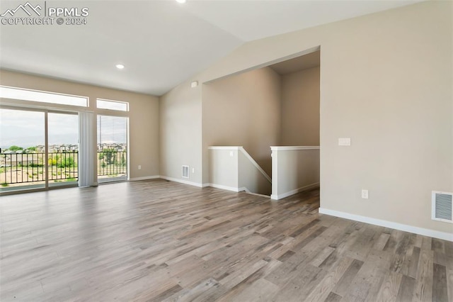 empty room featuring vaulted ceiling and hardwood / wood-style floors