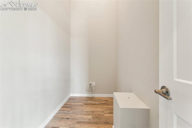 clothes washing area featuring light hardwood / wood-style floors