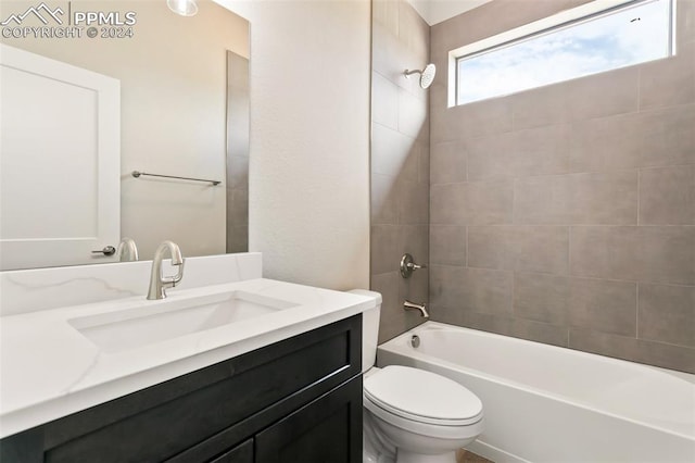 full bathroom with tiled shower / bath, toilet, and vanity with extensive cabinet space