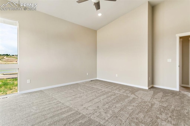 empty room featuring high vaulted ceiling, ceiling fan, and carpet floors