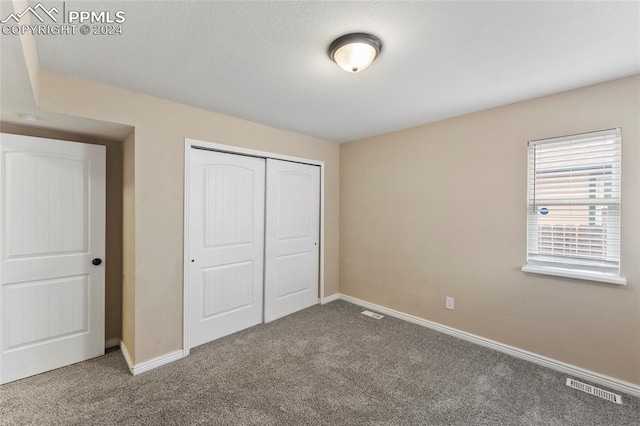 unfurnished bedroom featuring a closet and carpet floors