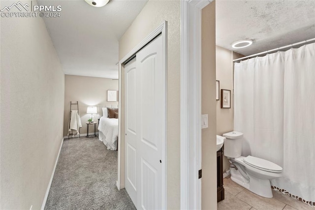 bathroom featuring tile flooring, vanity, and toilet