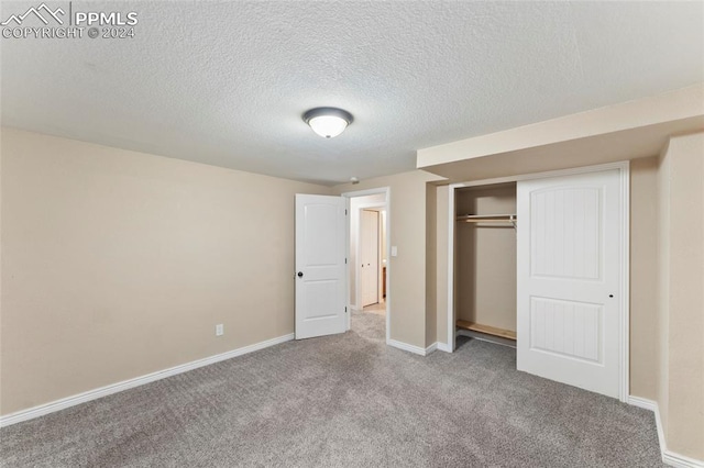 unfurnished bedroom with carpet, a closet, and a textured ceiling