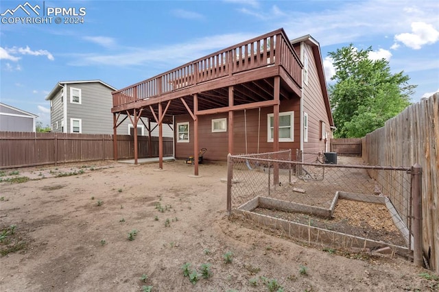 rear view of house with a wooden deck and central air condition unit