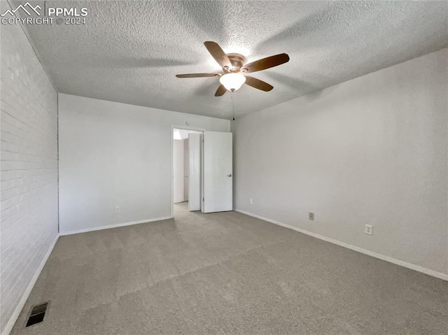 carpeted empty room with ceiling fan and a textured ceiling