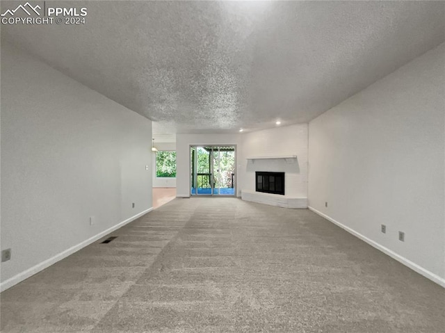 unfurnished living room featuring carpet and a textured ceiling