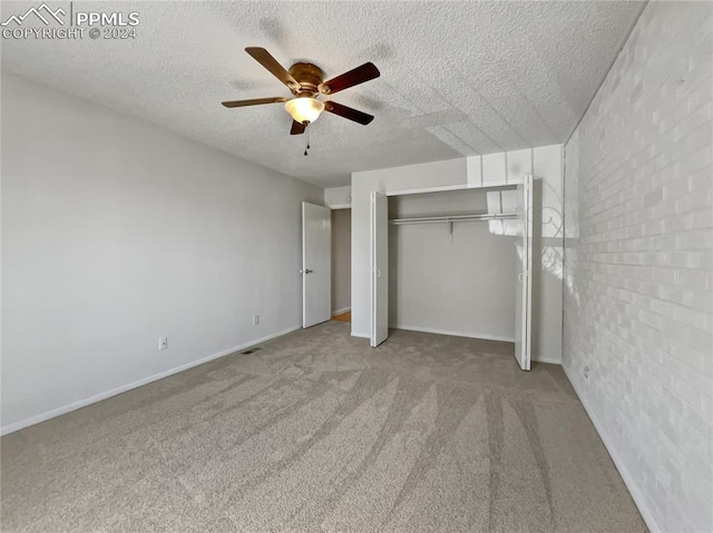 unfurnished bedroom with light carpet, a textured ceiling, a closet, and ceiling fan