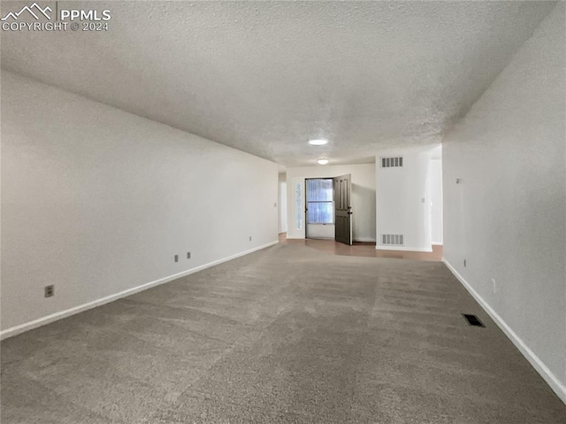 carpeted spare room with a textured ceiling