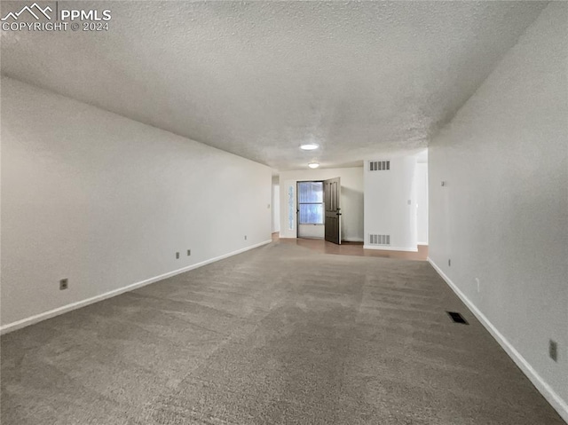 unfurnished room featuring carpet and a textured ceiling