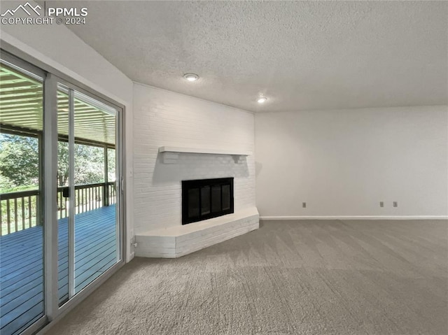 unfurnished living room featuring carpet flooring, a fireplace, and a textured ceiling