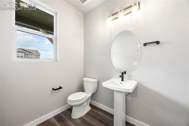 bathroom featuring hardwood / wood-style flooring and toilet