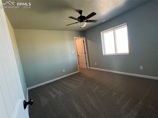 carpeted spare room with ceiling fan and a textured ceiling