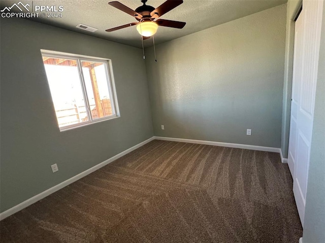 unfurnished room featuring ceiling fan, carpet floors, and a textured ceiling