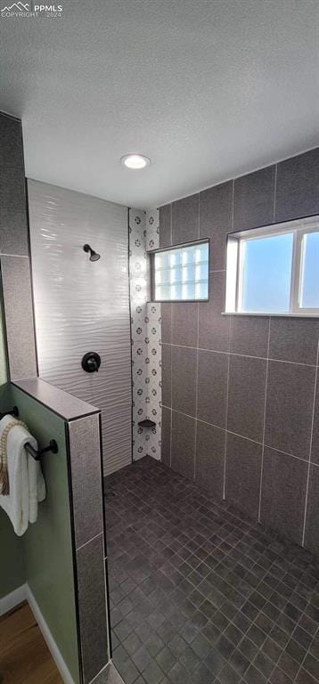 bathroom featuring a tile shower and a textured ceiling