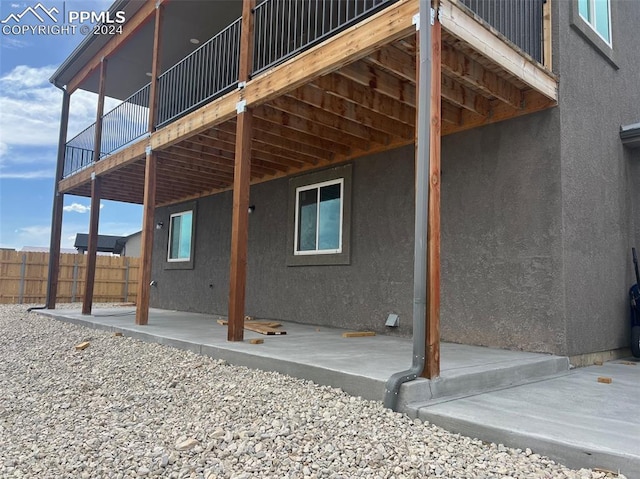 view of home's exterior featuring a wooden deck and a patio