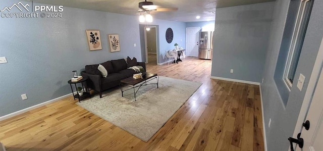 living room with hardwood / wood-style floors and ceiling fan