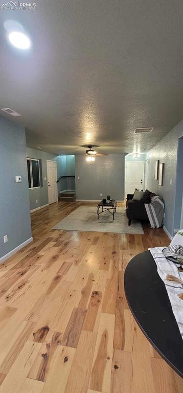 interior space featuring a textured ceiling, hardwood / wood-style flooring, and ceiling fan