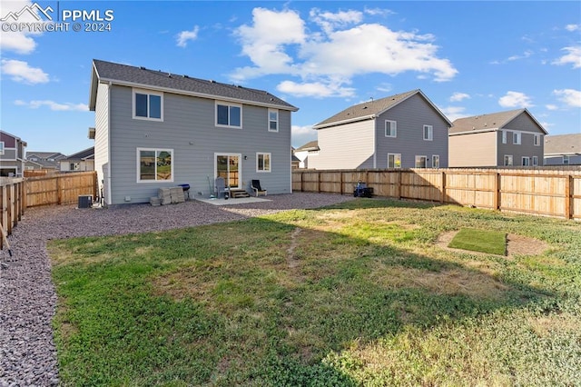 back of property with a lawn, a patio area, and central AC unit