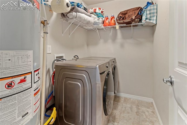 clothes washing area featuring separate washer and dryer and water heater