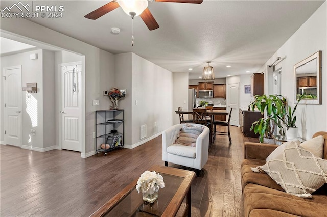 living room featuring ceiling fan and dark wood-type flooring