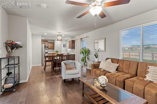 living room with ceiling fan and dark hardwood / wood-style flooring