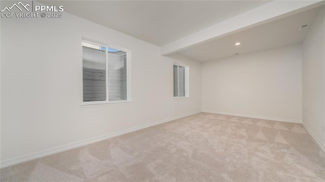 carpeted spare room with beam ceiling