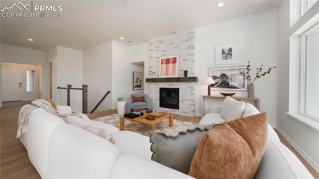 living room featuring light hardwood / wood-style flooring, a fireplace, and plenty of natural light