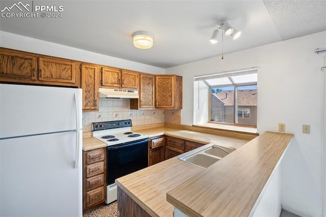 kitchen with backsplash, kitchen peninsula, sink, and white appliances