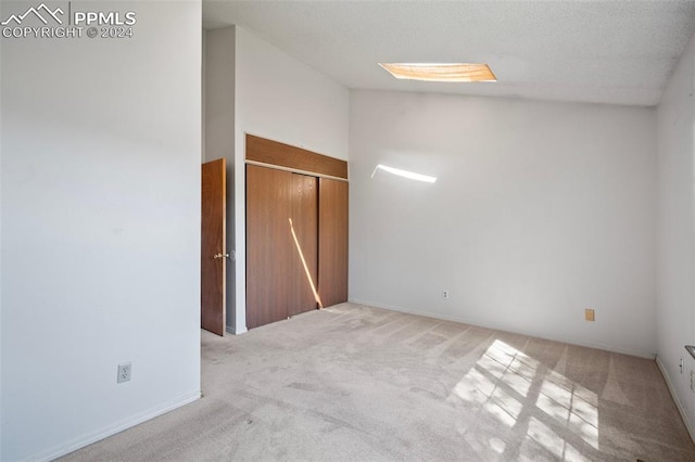 carpeted spare room with vaulted ceiling