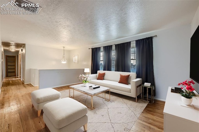 living room featuring light hardwood / wood-style flooring and a textured ceiling