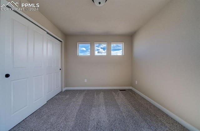 unfurnished bedroom with carpet flooring and a closet