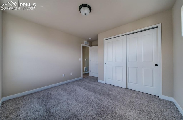 unfurnished bedroom featuring carpet and a closet