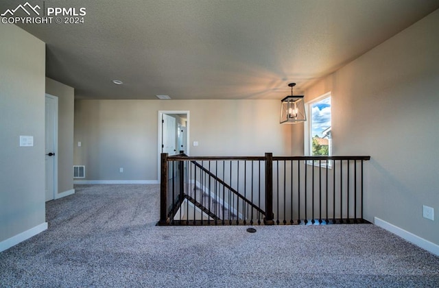 carpeted empty room with a textured ceiling