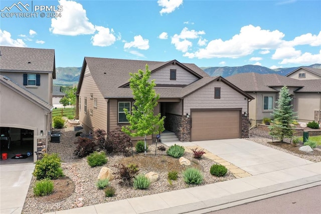 view of front of property with a mountain view, a garage, and central AC unit