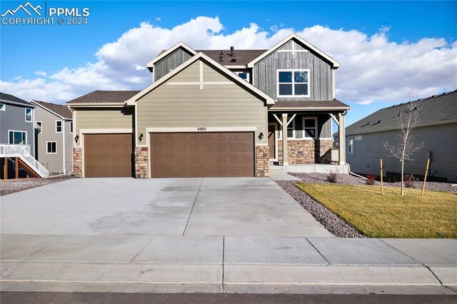 craftsman house featuring a garage and a front lawn