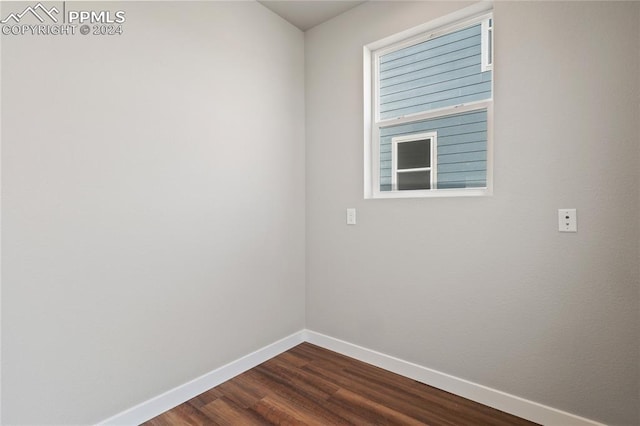 empty room featuring a wealth of natural light and dark hardwood / wood-style flooring