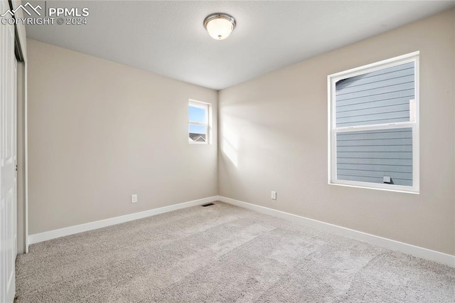 unfurnished room featuring light colored carpet