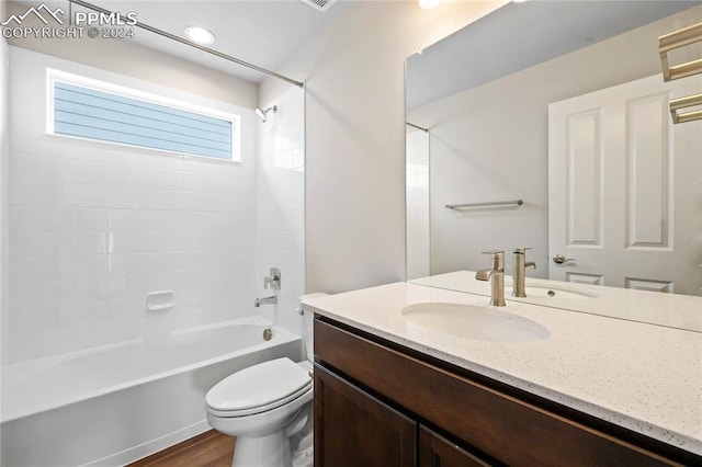 full bathroom featuring hardwood / wood-style flooring, vanity, toilet, and shower / tub combination