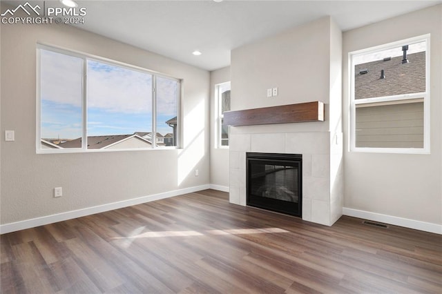 unfurnished living room featuring a fireplace and dark wood-type flooring