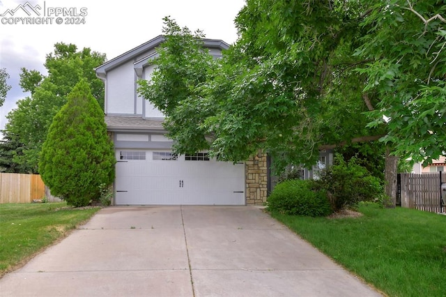 obstructed view of property featuring a garage and a front yard