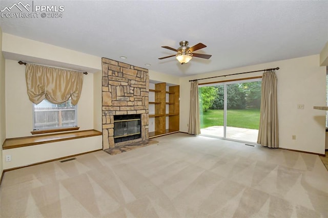 unfurnished living room featuring carpet flooring, ceiling fan, and a fireplace