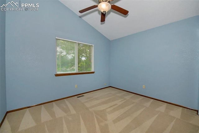 spare room featuring lofted ceiling, carpet, and ceiling fan