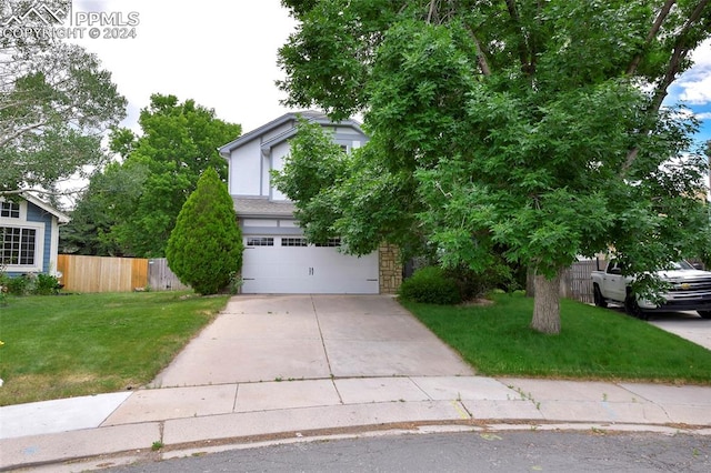 view of property hidden behind natural elements with a front yard and a garage