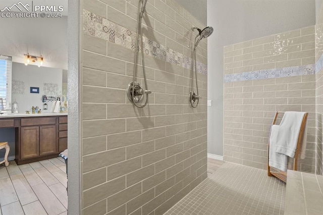 bathroom featuring a tile shower, vanity, and hardwood / wood-style flooring