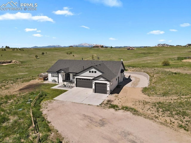 view of front of home with a mountain view, a rural view, and a garage