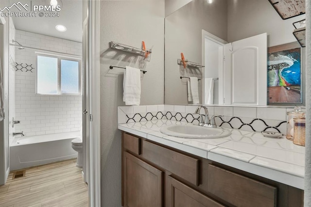 full bathroom featuring vanity, toilet, and tiled shower / bath combo