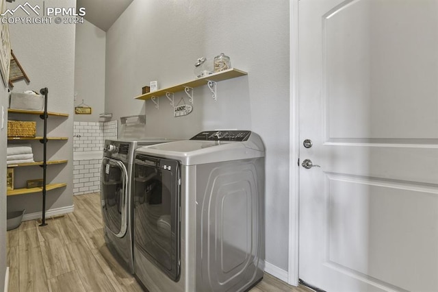 washroom with independent washer and dryer and light hardwood / wood-style floors