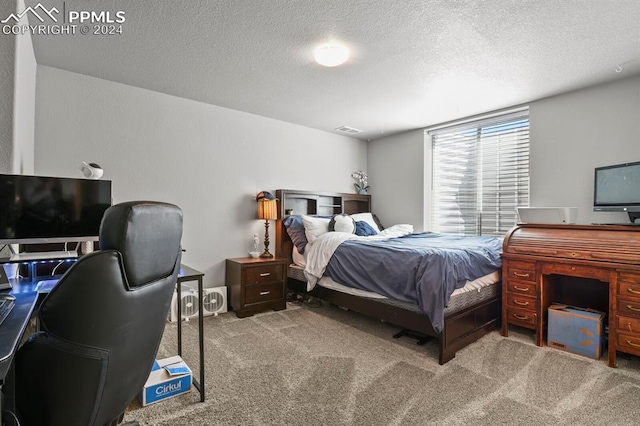 bedroom with carpet and a textured ceiling