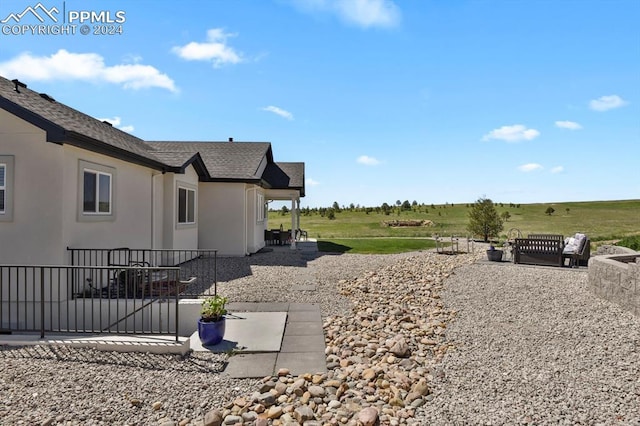 view of yard with a rural view and a patio