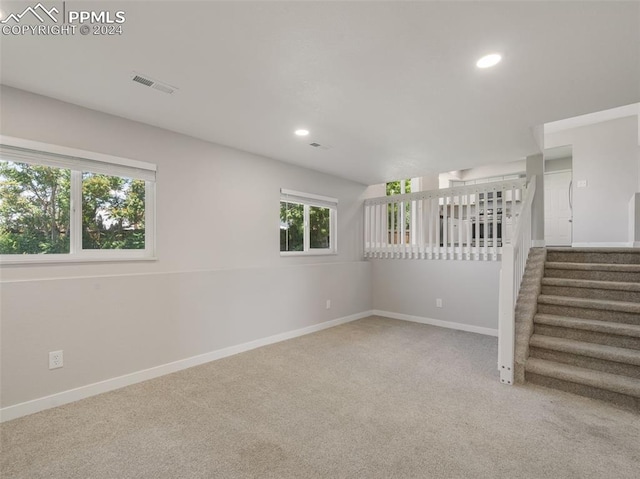 empty room with carpet flooring and a healthy amount of sunlight